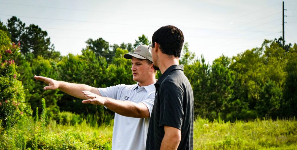 Two men discussing in a field.