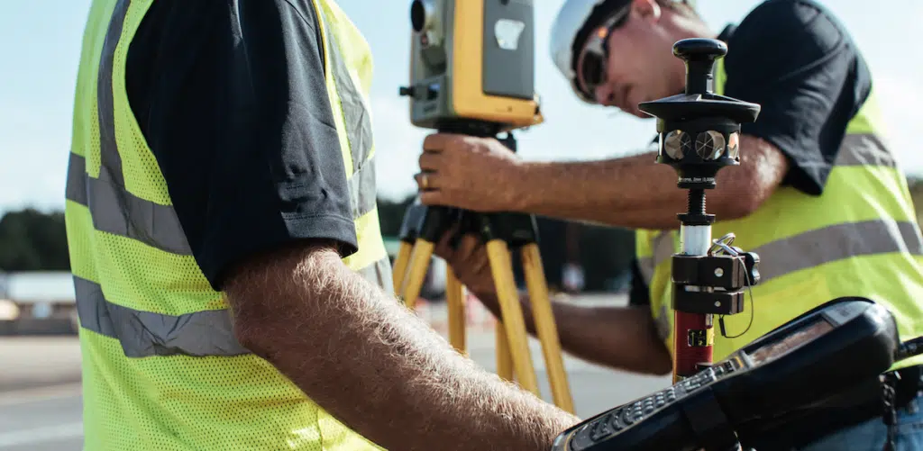 Surveyors using equipment outdoors.